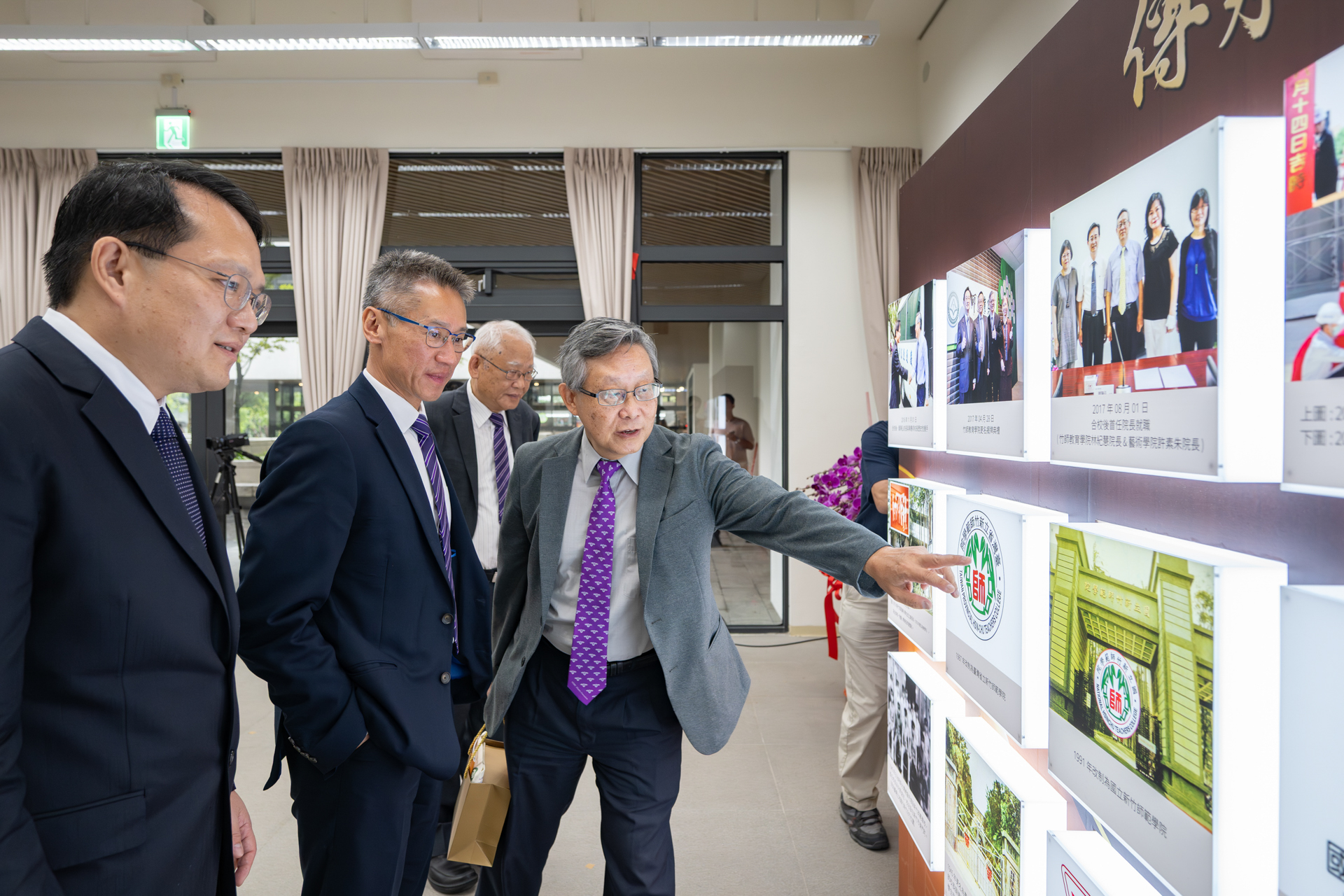 From left: College of Education dean Tzu-Hua Wang, NTHU president W. John Kao, Senior Vice President Nyan-Hwa Tai, and former NTHU president Hong Hocheng view a photo wall of the college's history.