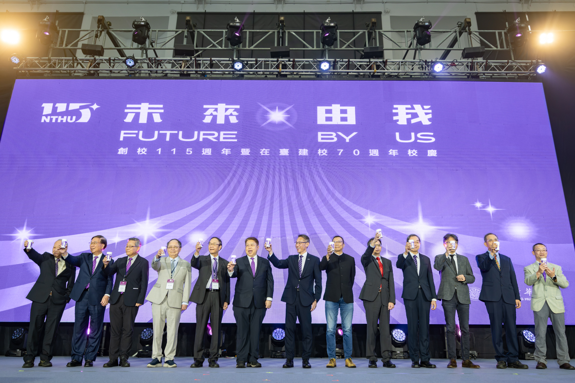 Members of the NTHU community gather on stage, raising reusable NTHU cups in a collective toast to mark the University’s 115th anniversary and 70th year in Taiwan.