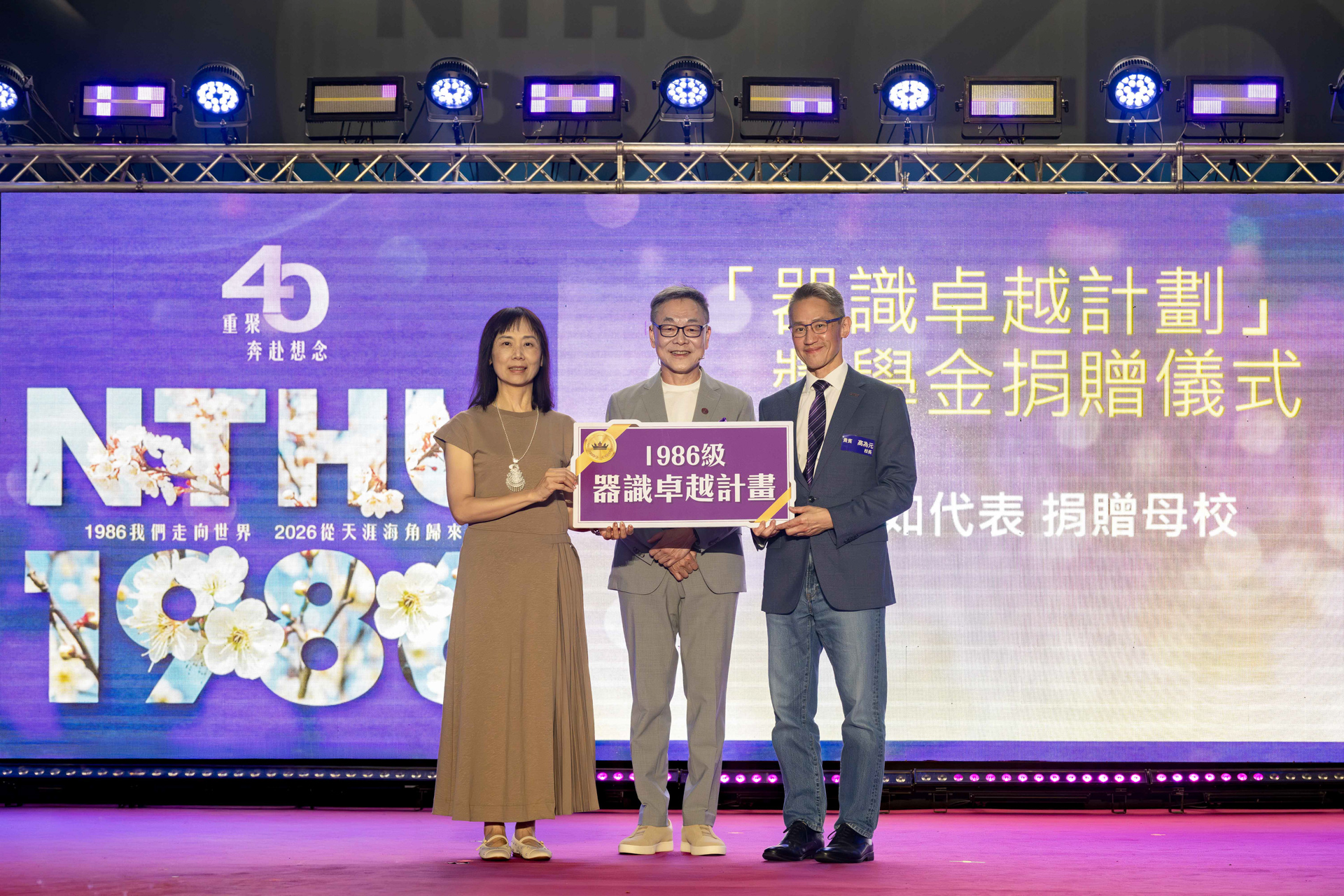 President W. John Kao (right) receives the scholarship donation for the 1986 Vision and Stature Leadership Program , presented by alumna Hsiang-Ju Liao (left) of the Class of 1986, with alumnus Shawn Wang (center) as witness.