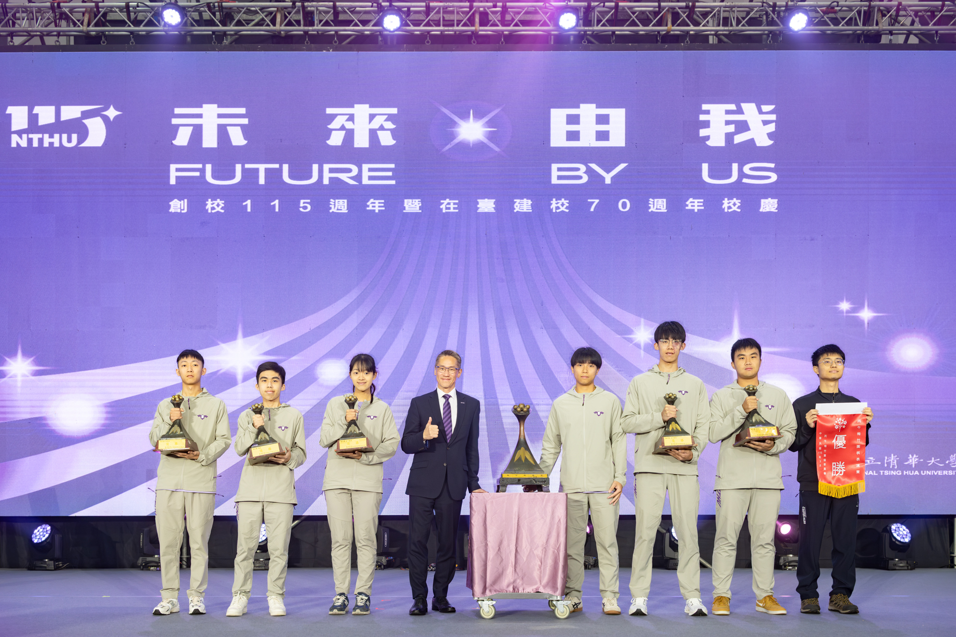 The university’s championship-winning athletic teams from the Mei-Chu Games present their trophies at the anniversary assembly, with President W. John Kao receiving the overall championship trophy on behalf of NTHU