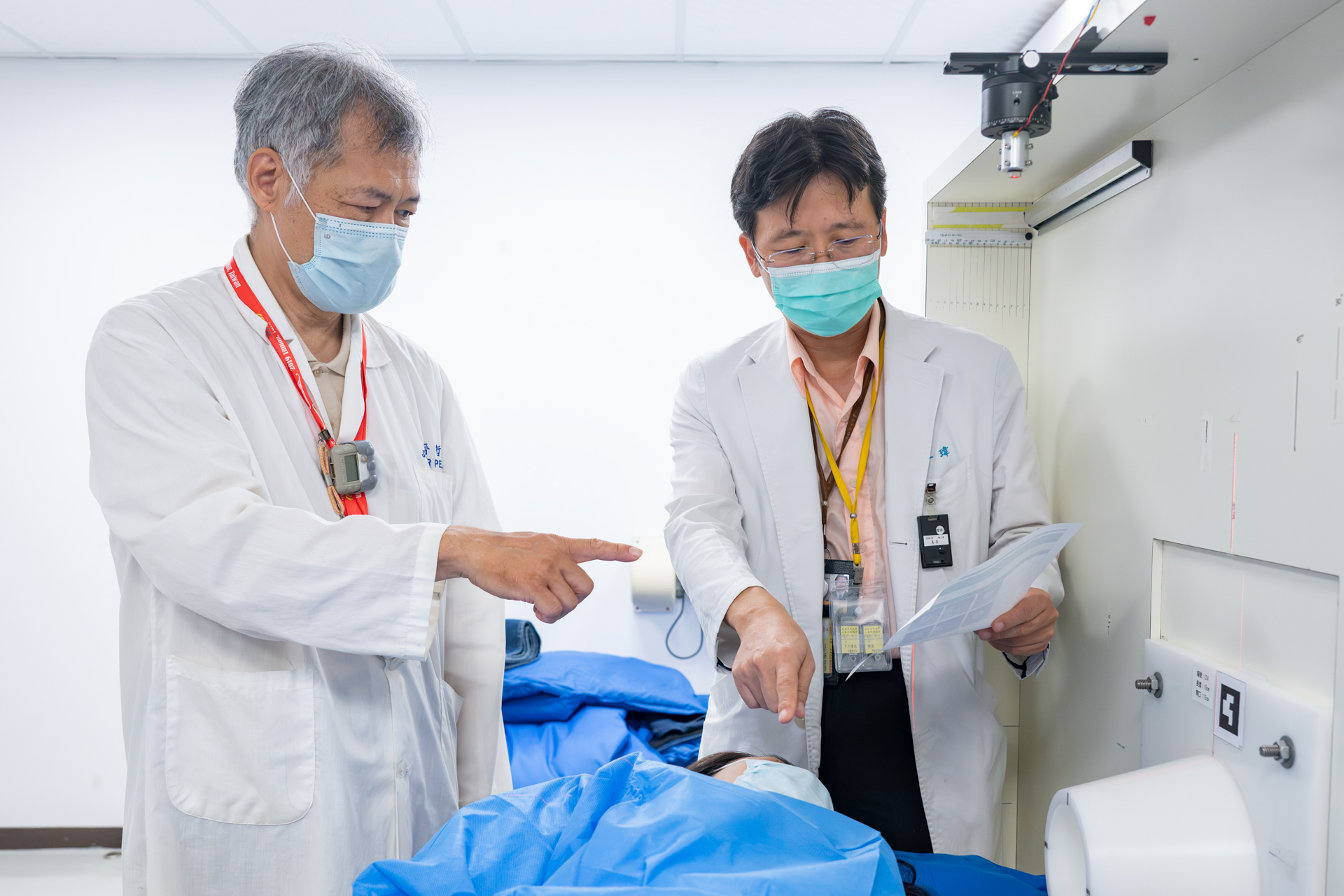 Nuclear engineer Jinn-Jer Peir (left), who is responsible for treatment planning, discusses the BNCT treatment process for a breast cancer patient with physician Yi-Wei Chen (right).